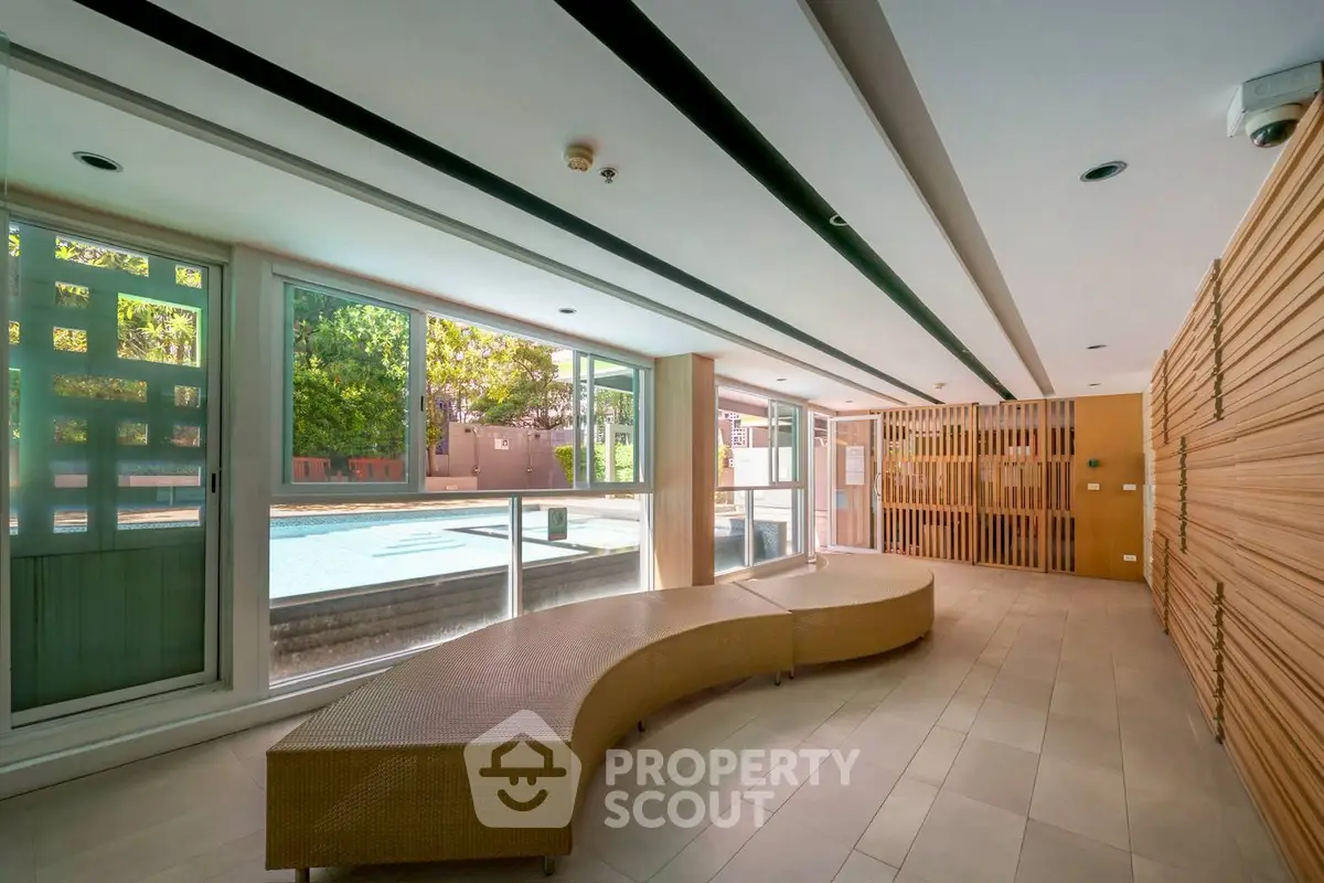 Modern indoor pool area with stylish seating and large windows