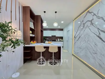 Modern kitchen with elegant marble wall and stylish bar seating in a contemporary home.