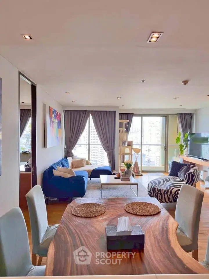 Spacious living room with modern decor and large windows offering city views