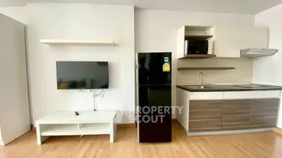 Modern studio apartment with sleek kitchen and TV setup