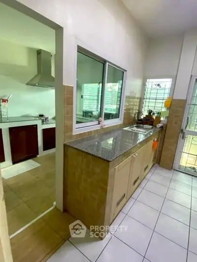 Spacious kitchen with granite countertops and modern appliances in a bright home.