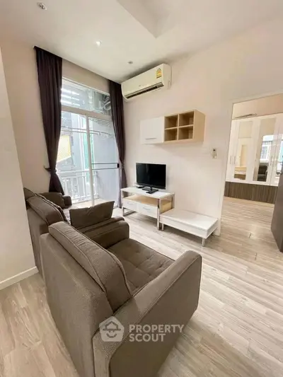 Modern living room with cozy seating and natural light in a stylish apartment.