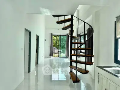Modern interior with spiral staircase and large windows offering natural light and garden view.