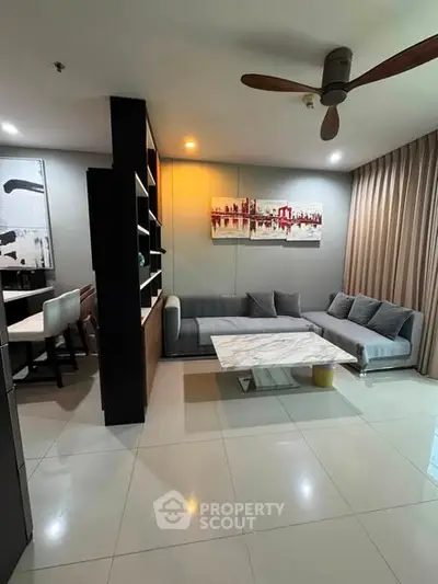 Modern living room with stylish decor and open layout, featuring a sleek marble coffee table and contemporary artwork.