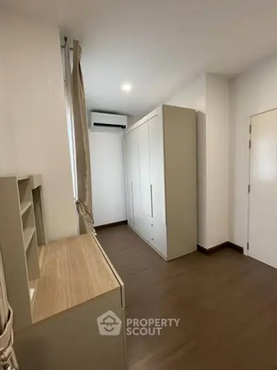 Modern bedroom with sleek wardrobe and wooden flooring