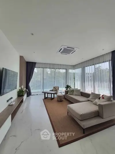 Spacious modern living room with large windows and elegant decor