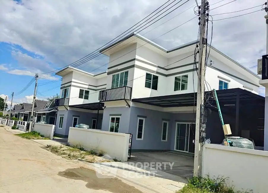 Modern two-story houses with sleek design and spacious driveways in a suburban neighborhood.