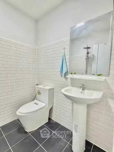 Modern bathroom with sleek white tiles and contemporary fixtures.
