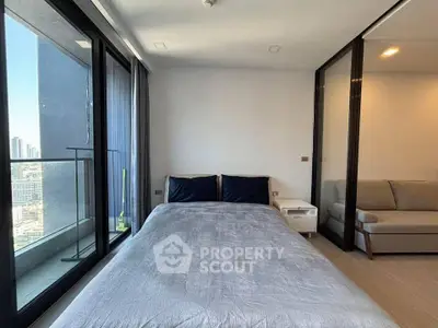 Modern bedroom with large windows and city view, featuring a cozy bed and stylish decor.