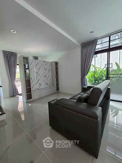 Spacious living room with modern decor and large windows for natural light