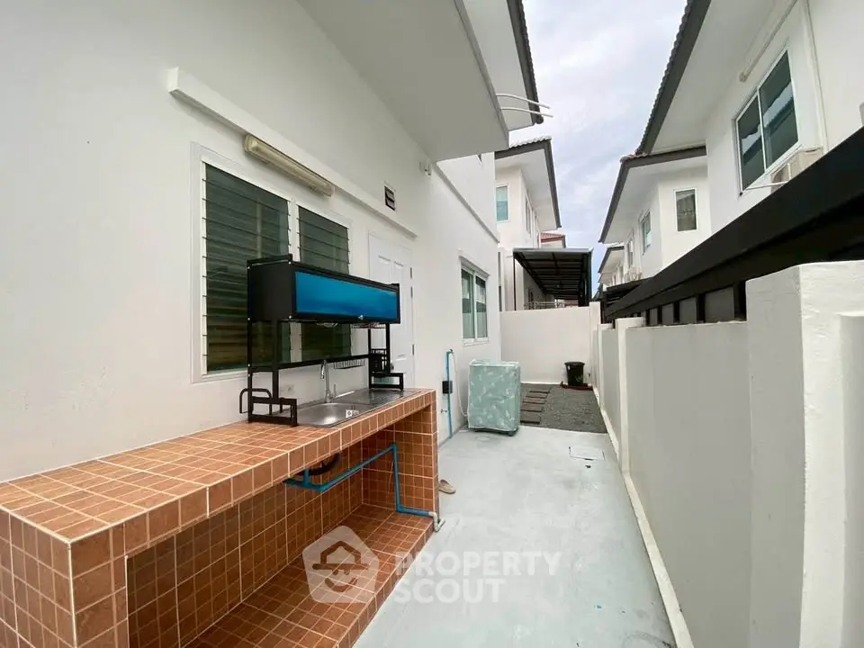 Modern exterior with tiled counter and sleek white walls in a contemporary home.