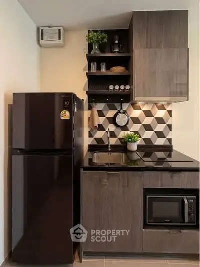 Modern kitchen with sleek black appliances and geometric backsplash design.