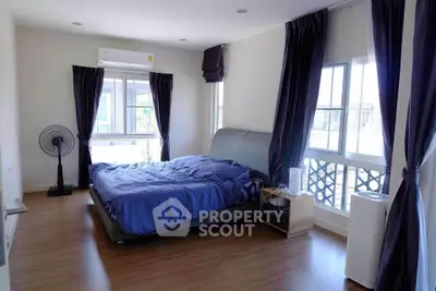 Spacious bedroom with modern decor and large windows for natural light