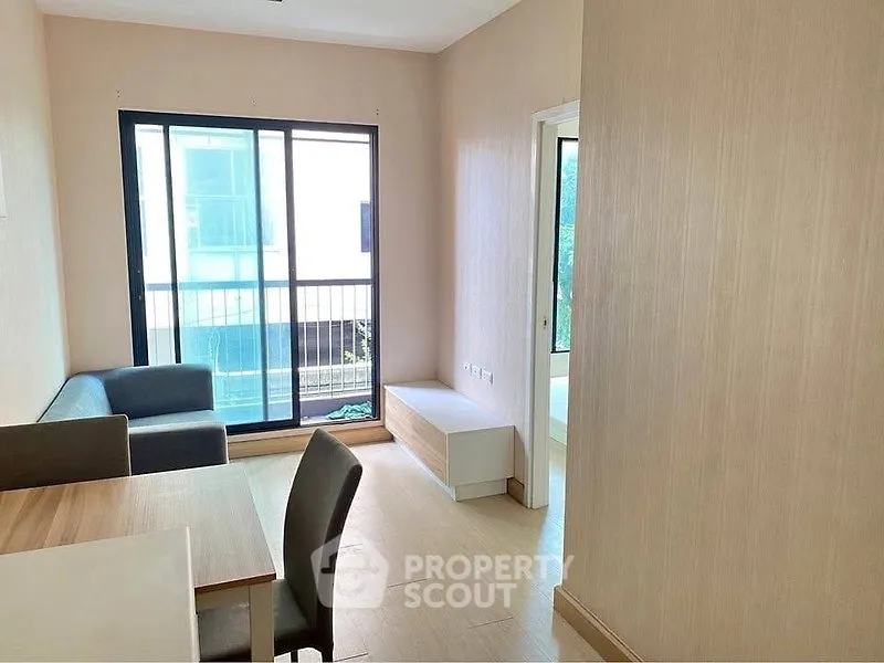 Modern living room with large window and stylish furniture in a bright apartment.