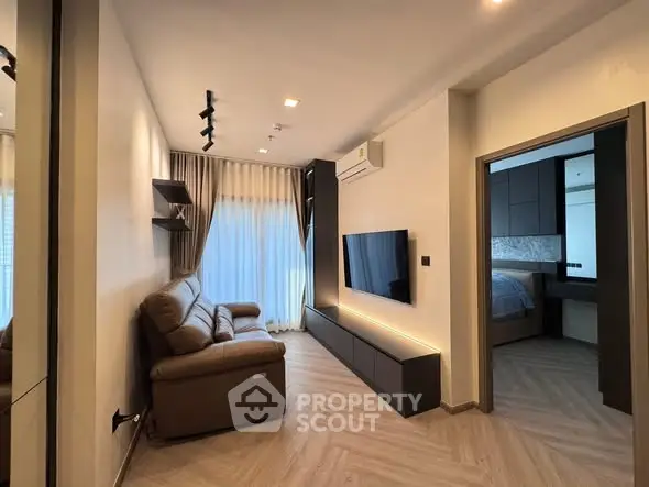 Modern living room with sleek design, featuring a cozy sofa, wall-mounted TV, and elegant lighting.