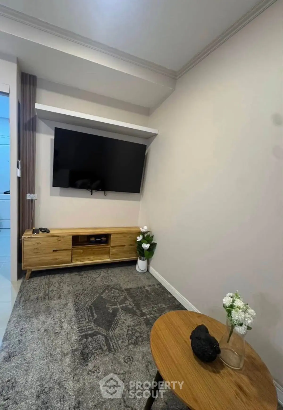 Modern living room with wall-mounted TV and stylish wooden furniture