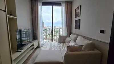 Modern living room with large window and city view, featuring a cozy sofa and sleek TV setup.