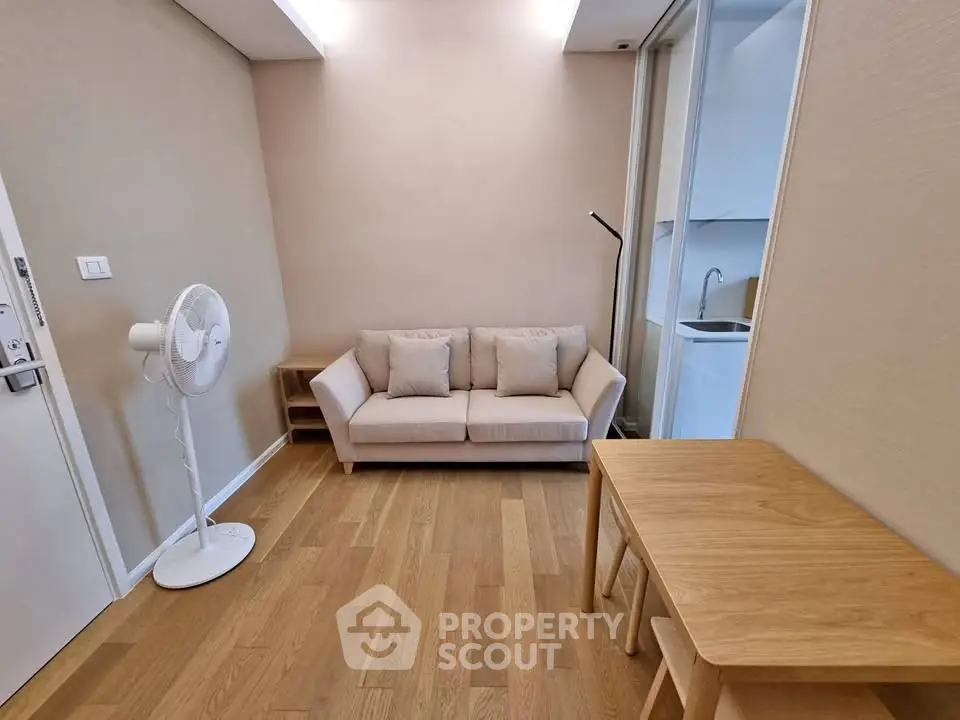 Cozy living room with wooden flooring, modern sofa, and a sleek floor lamp, perfect for relaxation.