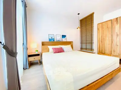 Bright and cozy bedroom with wooden furniture and large window.