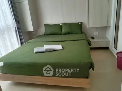 Modern bedroom with green bedding and natural light from large windows
