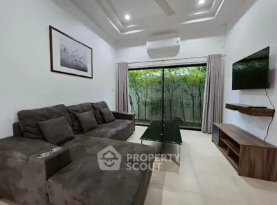 Modern living room with sleek furniture and large window view.