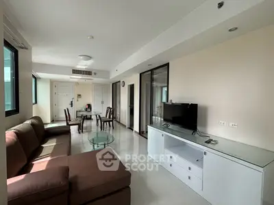 Spacious living room with modern furniture and natural light in a stylish apartment.