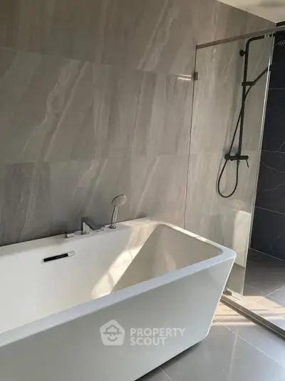 Modern bathroom with sleek bathtub and glass shower enclosure