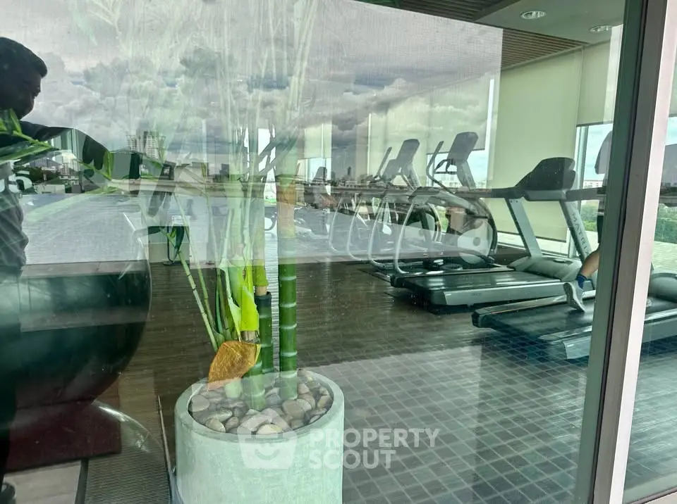 Modern gym with treadmills and panoramic city view, perfect for fitness enthusiasts.