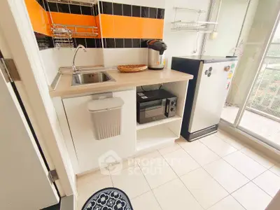Modern kitchen with sleek appliances and vibrant backsplash in a cozy apartment setting.