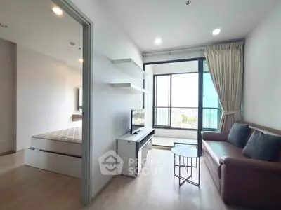 Modern apartment with cozy living room and bedroom, featuring large windows and stylish furnishings.