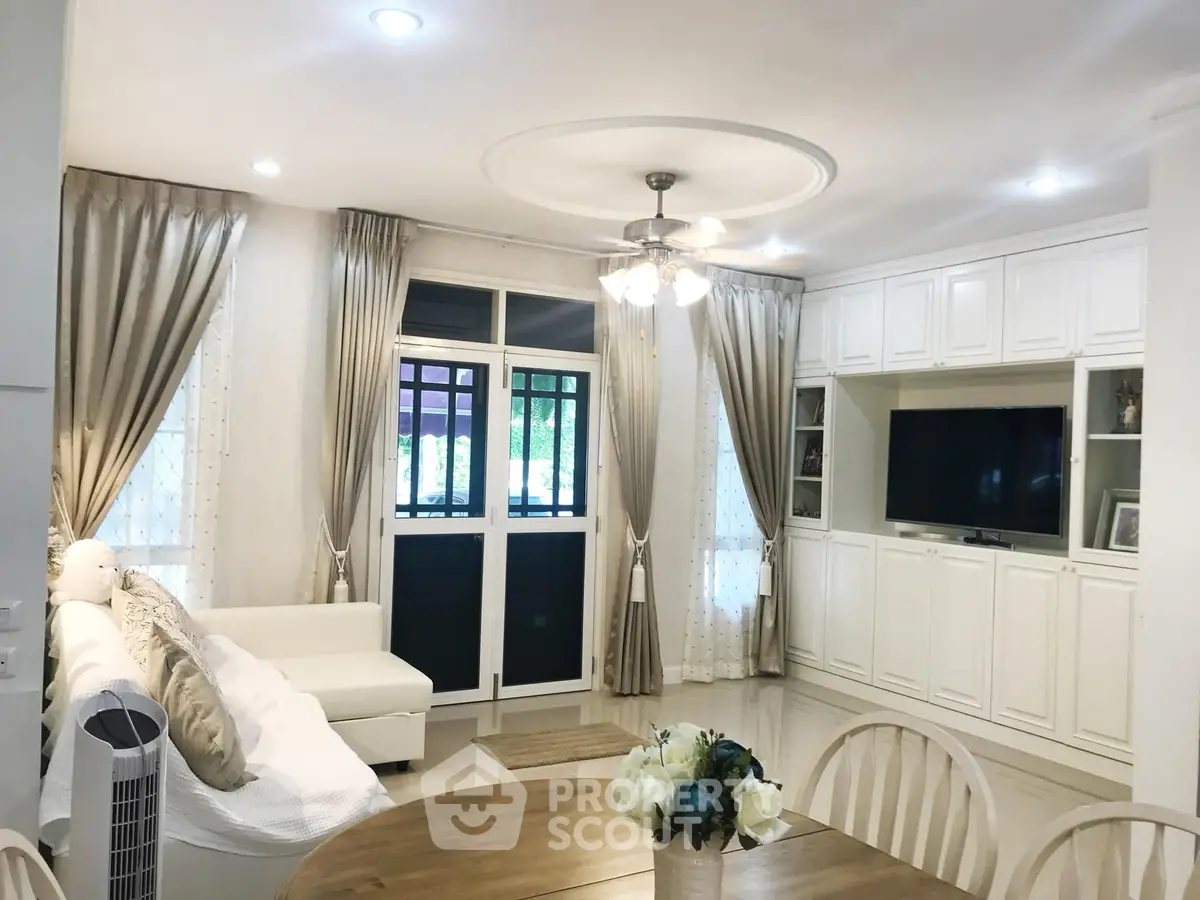 Elegant living room with white decor and large windows for natural light