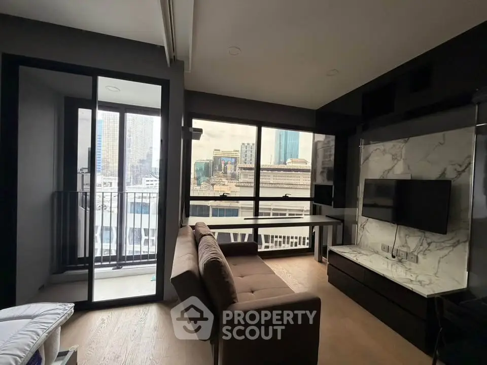 Modern living room with city view, featuring sleek furniture and large windows for natural light.
