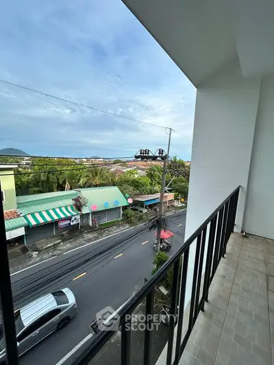 Spacious balcony with scenic street view in a vibrant neighborhood.