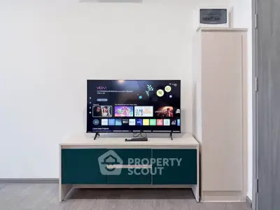 Modern living room with sleek TV stand and flat-screen TV, perfect for entertainment.