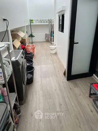 Spacious laundry area with modern washing machine and ample storage space.