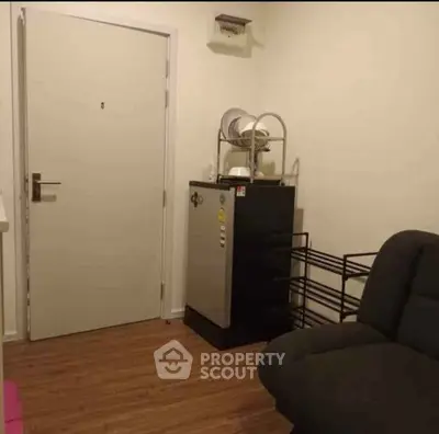 Cozy interior with compact fridge and dish rack, perfect for small spaces.