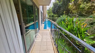 Luxurious apartment with poolside balcony and lush greenery view