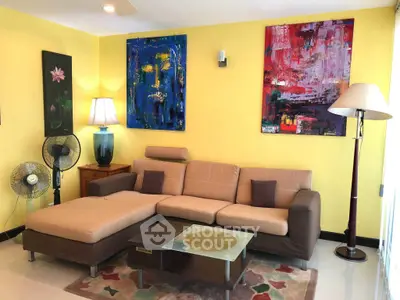 Stylish living room with modern art and cozy sectional sofa in vibrant colors.