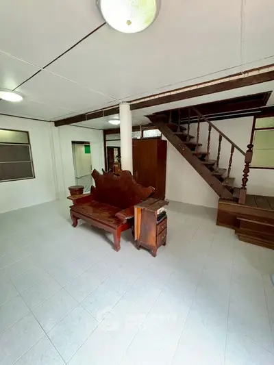 Spacious living room with wooden staircase and unique furniture