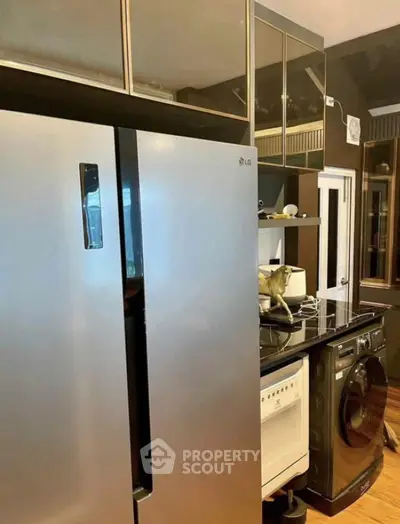 Modern kitchen with stainless steel fridge and washing machine