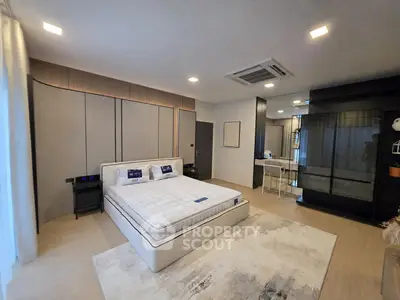 Spacious modern bedroom with elegant decor and large bed in luxury apartment.
