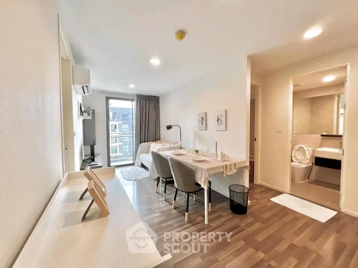 Modern open-plan living room with dining area and study nook, featuring stylish decor and natural light.