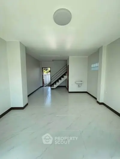 Spacious modern interior with sleek staircase and minimalist design, perfect for contemporary living.