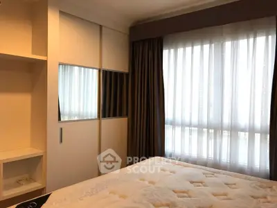 Cozy bedroom with large window and built-in wardrobe in modern apartment