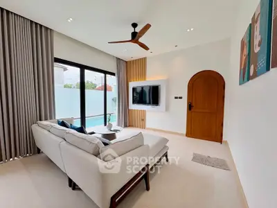 Modern living room with pool view, featuring stylish sofa and wall-mounted TV.