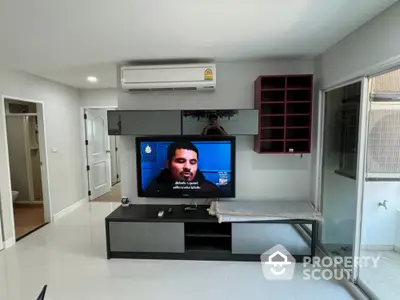 Modern living room with sleek TV setup and air conditioning unit