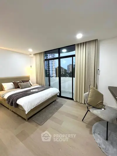 Modern bedroom with large windows and city view, featuring stylish decor and cozy ambiance.