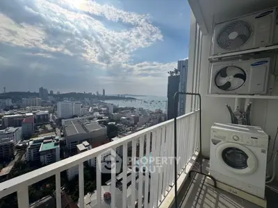 Stunning high-rise balcony with city and ocean view, featuring modern appliances.