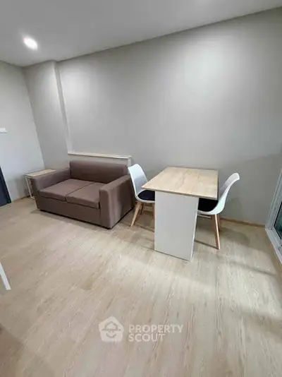 Modern living room with minimalist furniture and wooden flooring in a cozy apartment.