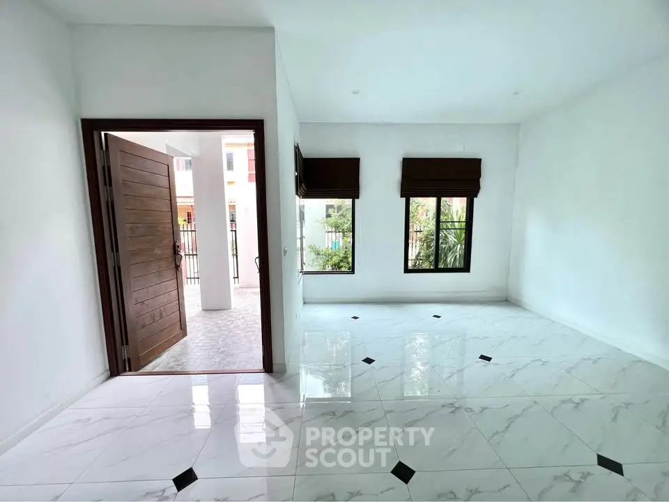 Spacious modern living room with elegant tile flooring and large windows for natural light.